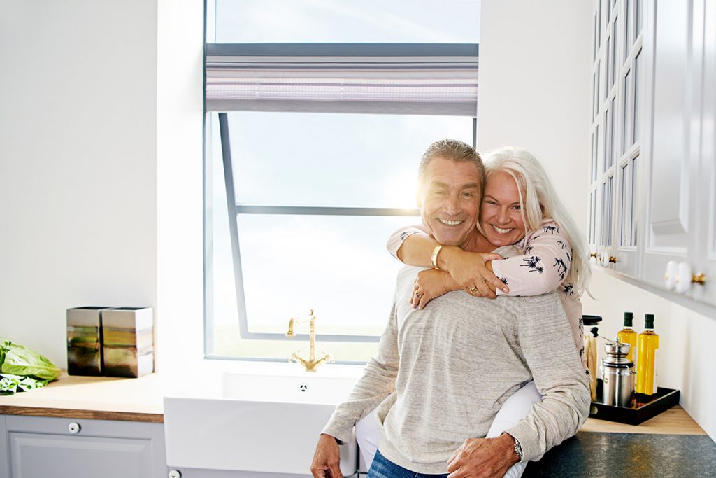 Older couple hugging in a kitchen