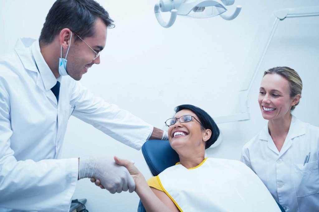 Woman shaking hands with her dentist