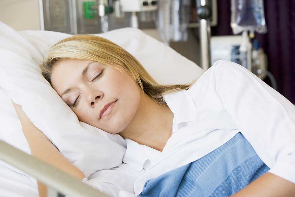 Sleeping woman in medical bed.